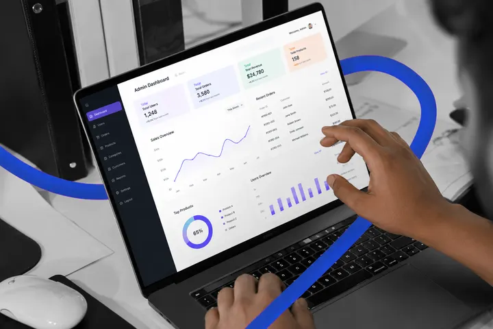 A website admin dashboard with sales and visitor charts on a laptop