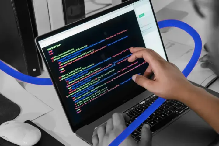 A developer writing website code on a laptop