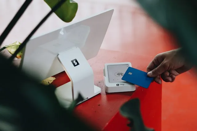 A customer paying by bank card at a point-of-sale terminal